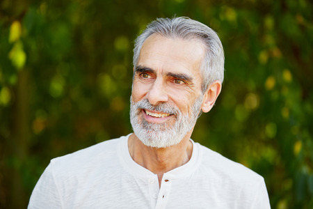 Senior retired man smiling with joy in summer in the natureの写真素材