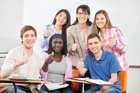 Successful group of students with their thumbs up