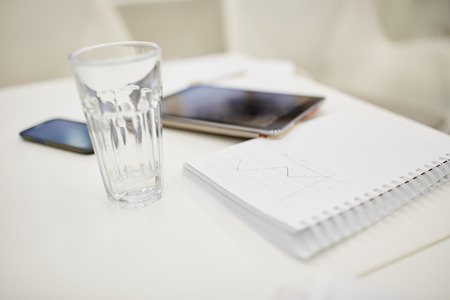 Tablet next to a smartphone and notes in a business meetingの写真素材