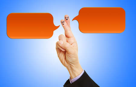 Smileys on fingers talking in a chat with two speech bubblesの写真素材