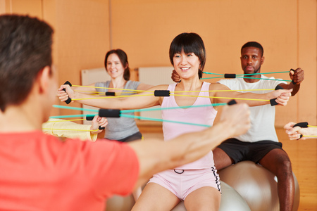 Interracial group with expanding bands during rehab class