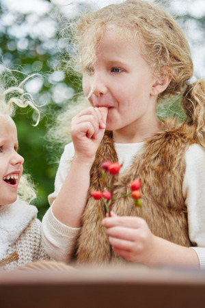 Girl sucking her thumb and picking rosehips in the fallの写真素材