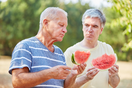 Two seniors eating watermelon in summerの写真素材