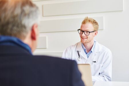 Doctor and patient talking at his officeの写真素材