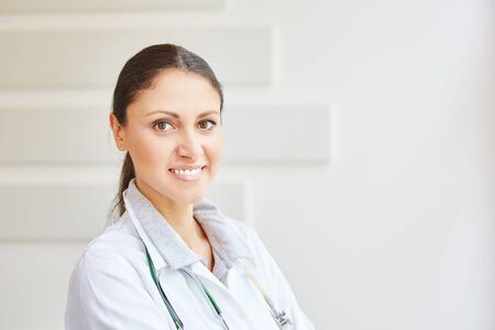 Young woman as doctor in hospital looking friendlyの写真素材