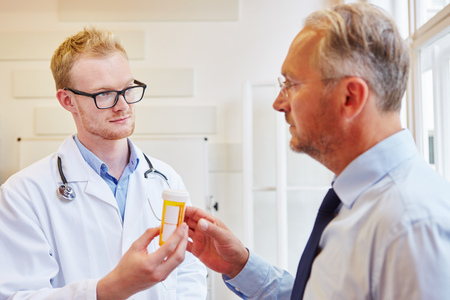 Doctor gives medicament to senior patient for treatmentの写真素材
