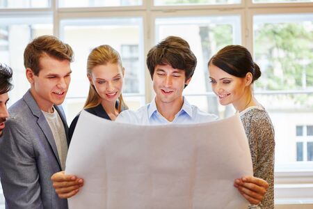 Start-up team looking at project plan in office