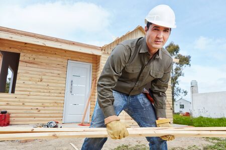 Man as handyman at construction site building woodhouse