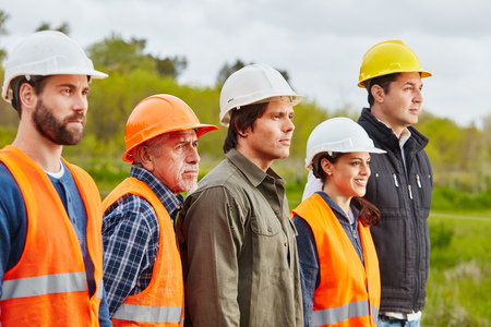 Craftsmen team of collegues as a group using protective clothes