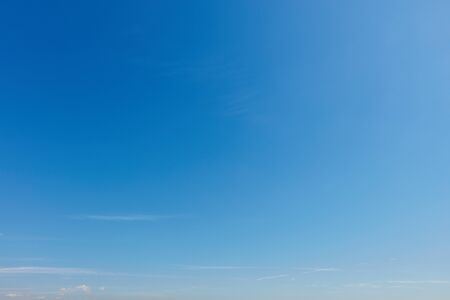 Empty blue sky background with some little cloudsの写真素材