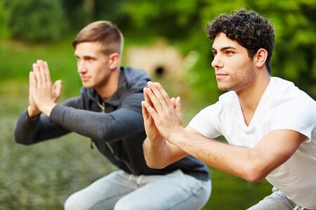 Young men doing squats as workout exerciseの写真素材