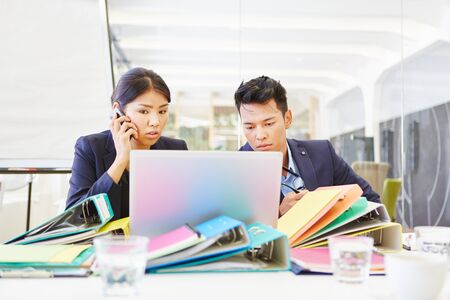 Asian start-up entrepreneur with computer at work