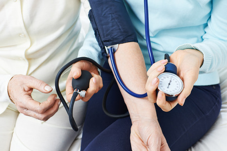 Blood pressure monitoring on arm of senior woman