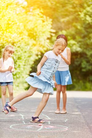 Children play hopscotch in summer in kindergartenの写真素材