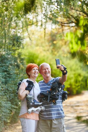 Senior couple with skates in the nature taking a selfieの写真素材