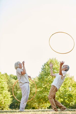 Smiling senior couple traning with tires for fitness training in the parkの写真素材