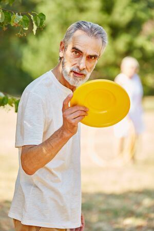 Old man with a flying disc in summer in the natureの写真素材