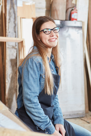 Woman as carpenter apprentice smiling content during her traineeの写真素材