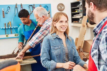 Young woman as trainee in carpenter's workshop