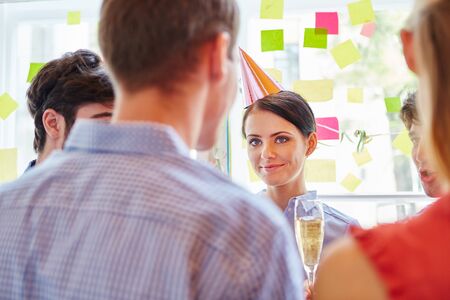 Woman celebrating with team in party in start-up companyの写真素材