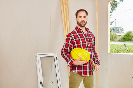 Confident blue collar worker at construction site building house