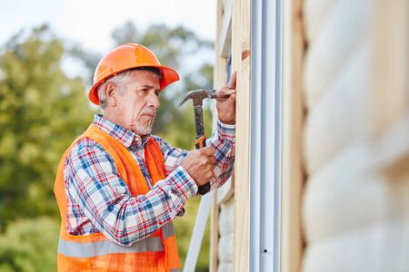 Senior citizen as building construction craftsman working on new houseの写真素材