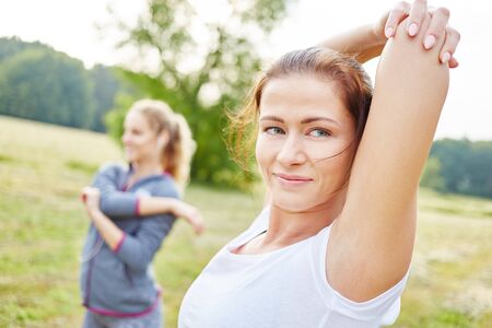 Women stretching during fitness class at the parkの写真素材