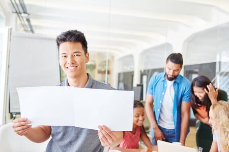 Start-up man holding blank pages in business workshopの写真素材
