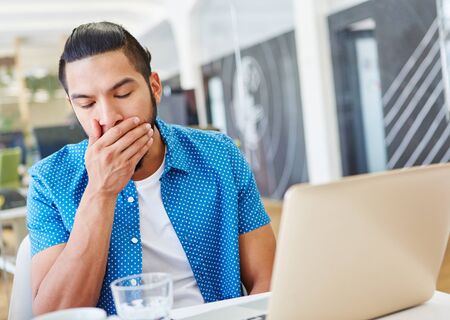 Tired programmer working overtime with computer at officeの写真素材