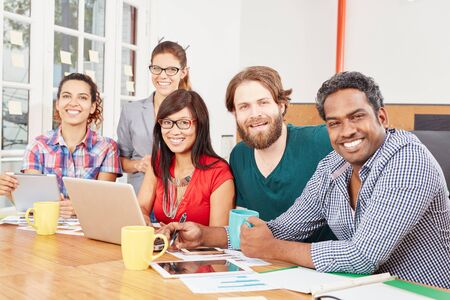 Interracial team in startup business office working with computer
