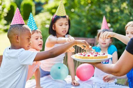 Interracial children children with cake at birthday partyの写真素材
