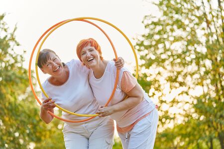 Two active women having fun in the park with hoops in the parkの写真素材