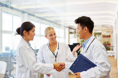 Young doctors shaking hands and welcoming each otherの写真素材