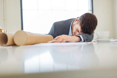 Stressed and exhausted businessman with burnoutの写真素材