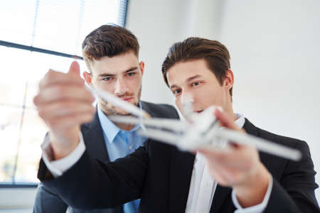 Designers holding innovative airplane model in start-up planning meetingの写真素材