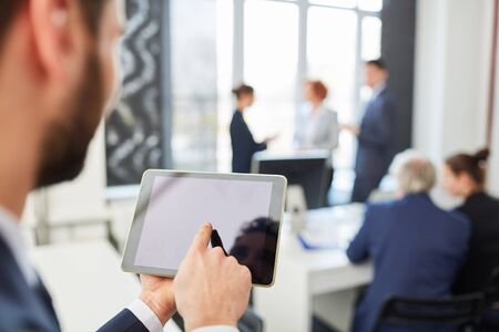 Man typing on tablet's touchscreen in internet and online strategy workshopの写真素材