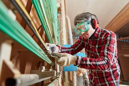 Carpenter with plate saw preparing for woodworking