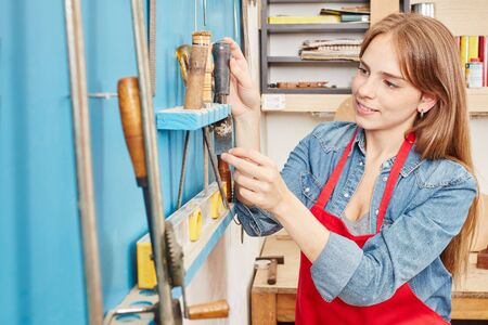 Joiner as apprentice looking for tools in carpentry shopの写真素材