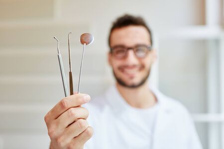Young dentist with tools and dental instrumentsの写真素材