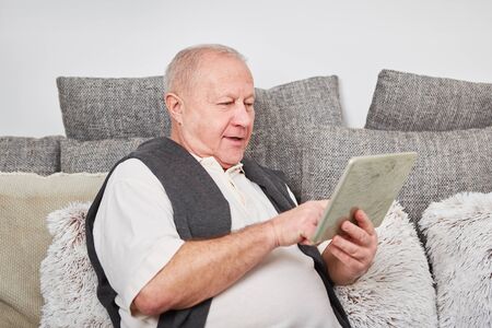 Senior citizen with tablet computer learns about technologyの写真素材