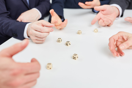 Hands playing roll the dice game as business team building exercise