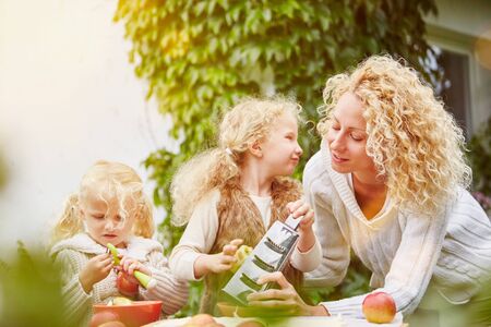 Mother and children rubbing apples for baking