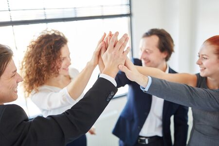 Successful team giving High Five in start-up meeting