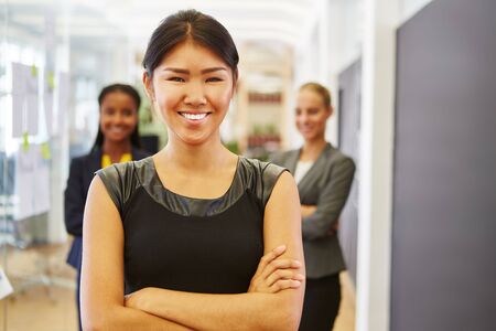 Young woman as trainee with her successful business teamの写真素材