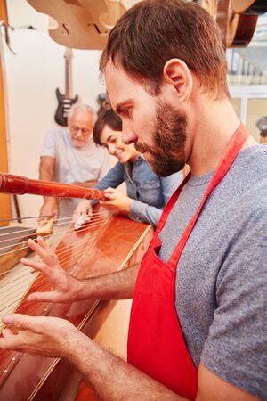 Expert luthier repairs harp carefully with his team