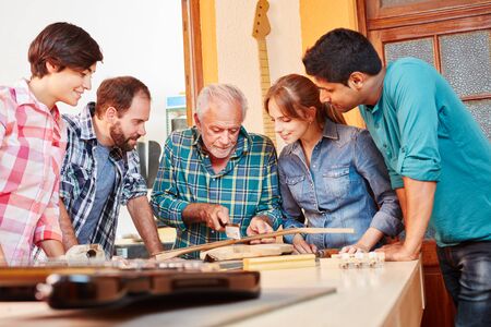 Group of guitar makers learning about luthier's workの写真素材