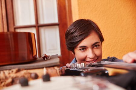 Woman as apprentice controls quality of new electric guitar