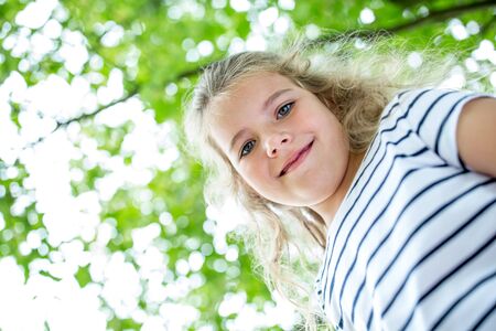 Blond girl in summer in the nature with a smile