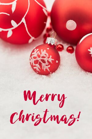 Merry christmas on holiday card with red baubles as decoration