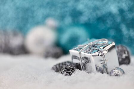Silver gift or present on the snow as christmas background for greeting cardの写真素材